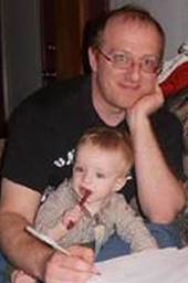 Zach Teitler, shown here grading exams with his son’s help, is an associate professor of math at Boise State University. 