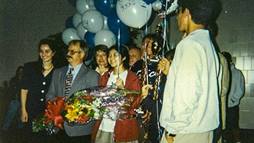 Candice Kamachi (in red coat) and her teammates were greeted as they arrived home in California after winning the 1996 National Science Bowl® in Washington, D.C.